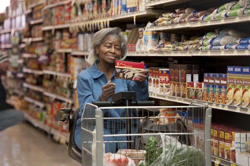 Senior woman grocery shopping with assistance